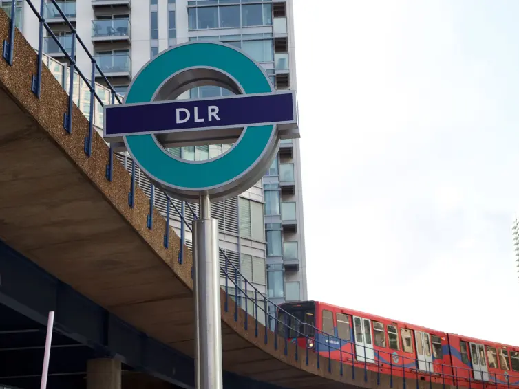 DLR sign with train in background.