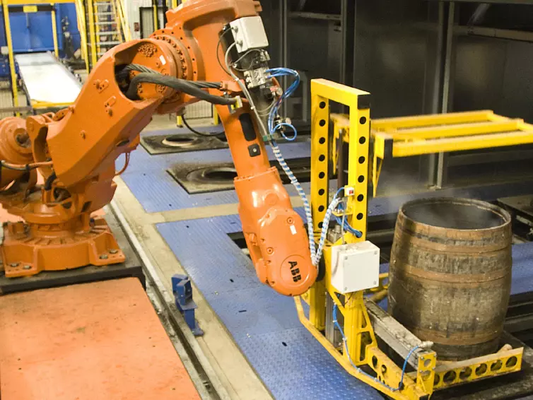 Robotic conveyor system moving barrels.