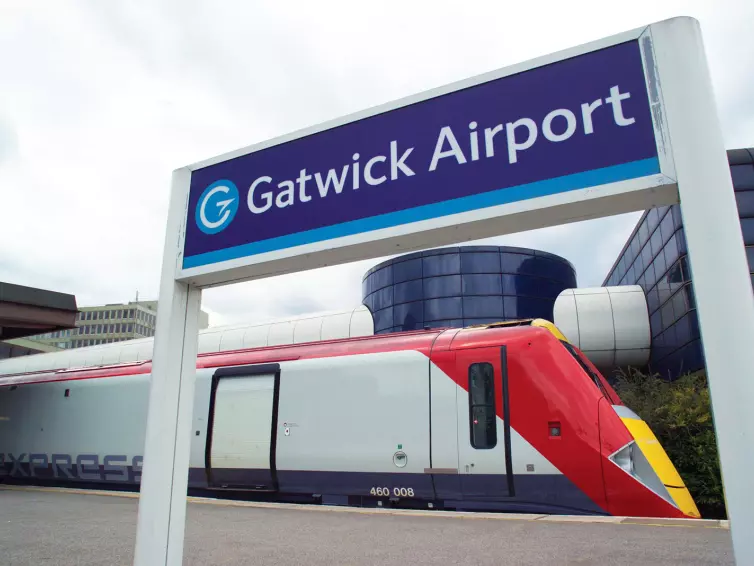 Trem Gatwick Express na estação, placa do Aeroporto de Gatwick.