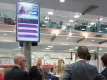Personas debajo de una pantalla de información para billetes