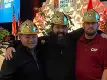 trois hommes en casques dorés souriant devant une scène au Precast Show