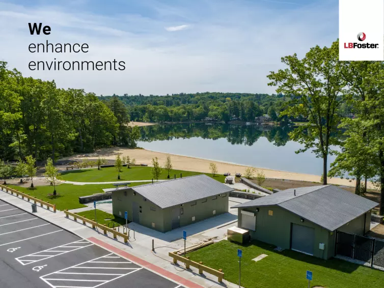 A birdseye view of two CXT concrete precast buildings within a small park area. There are many trees in the distance and a large lake. text on the image says 