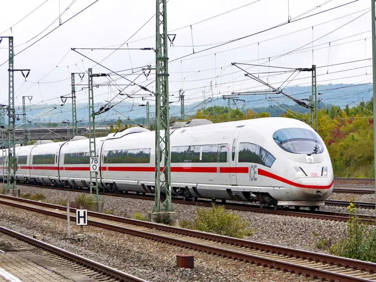 un tren blanco de alta velocidad circulando por una vía durante el día.