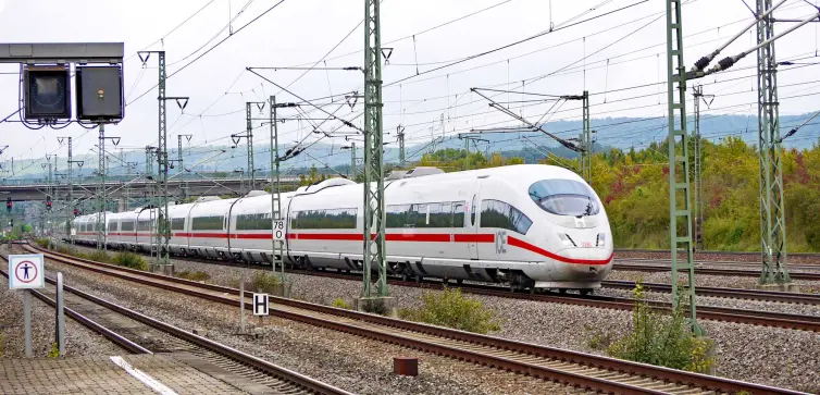un tren blanco de alta velocidad circulando por una vía durante el día.