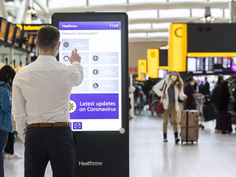 man using inform digital totem at heathrow airport.