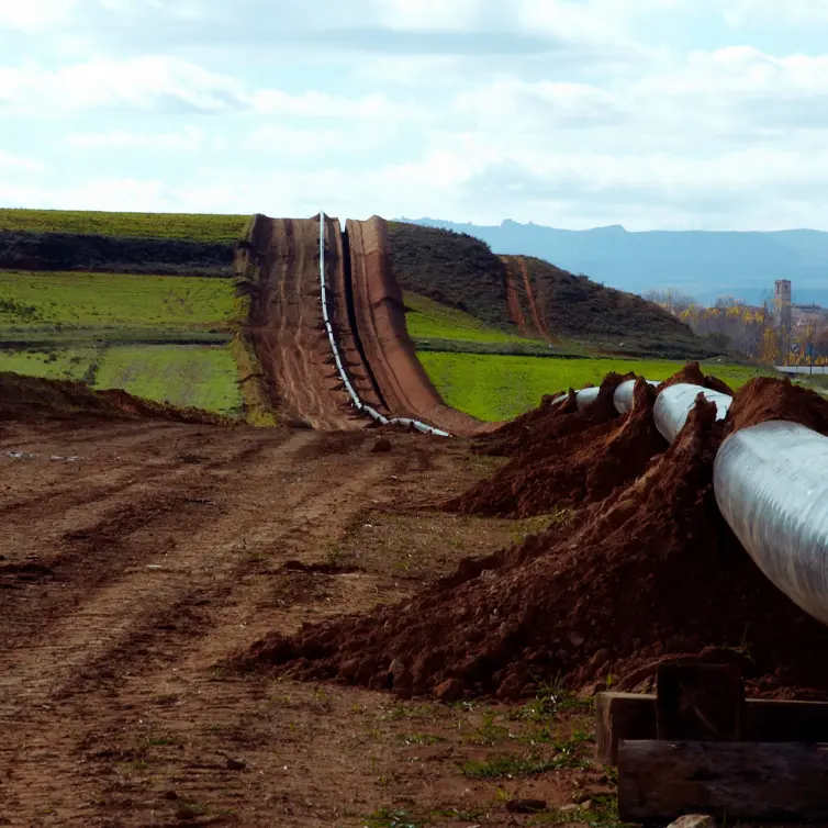 Teal coated pipe laid on the ground.