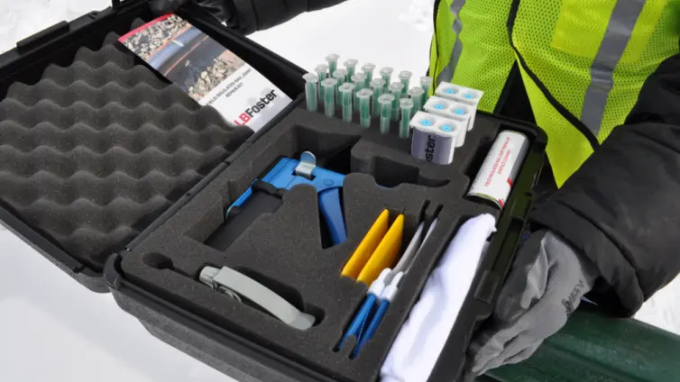 Caja abierta que muestra el kit con limpiador de superficies, pistola aplicadora, adhesivo de relleno, pulverizador con herramienta de inmersión, boquilla mezcladora, bolsas dispensadoras resellables, esparcidor, cepillo para quitar el polvo y trapos de tela.