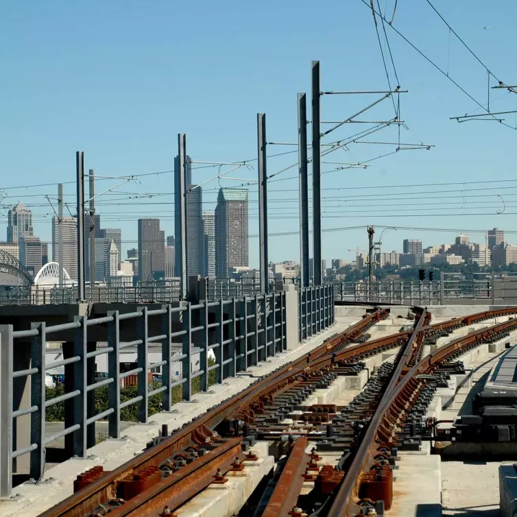 railroad track shown with city skyline in the background.