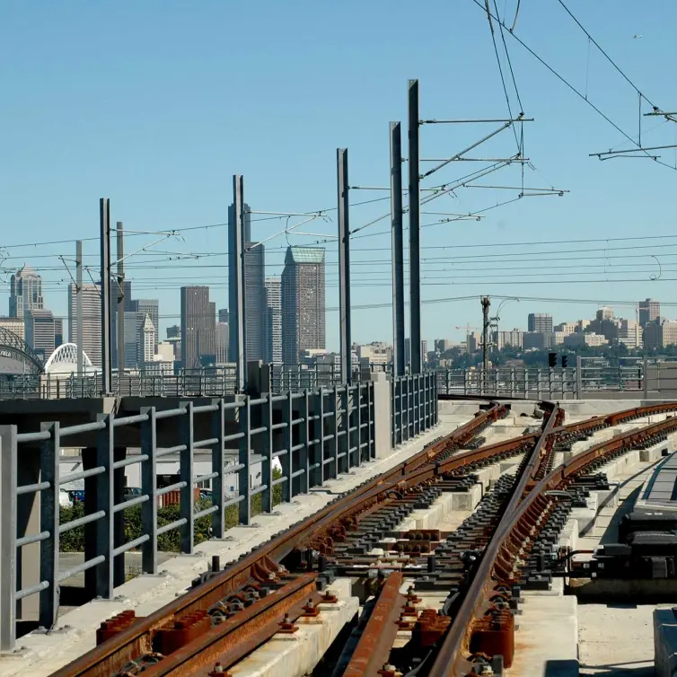 trilho de trem mostrado com o horizonte da cidade ao fundo.