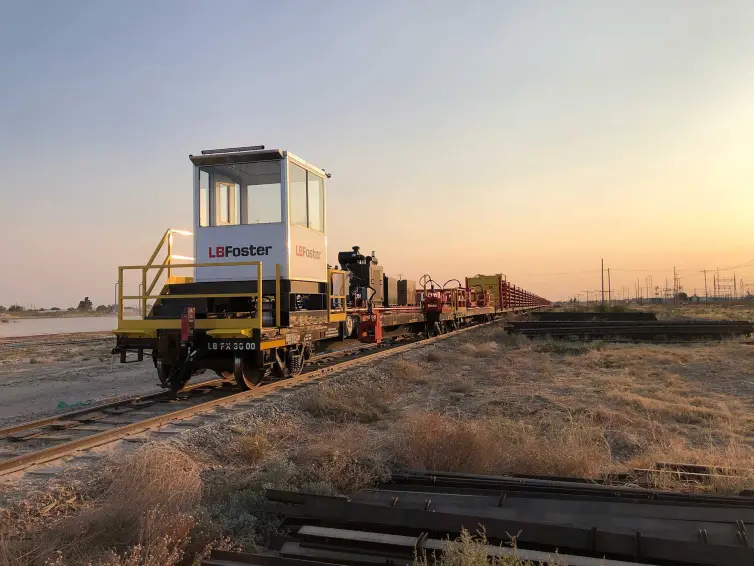 LB Foster a fait un étui de train de marque LB Foster transportant du matériel sur une voie ferrée.