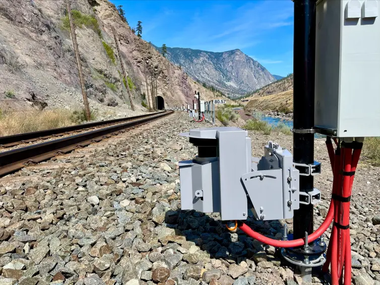 Felssturz-LiDAR, installiert neben einer Eisenbahnstrecke, die durch einen Tunnel in einem Berghang verläuft.