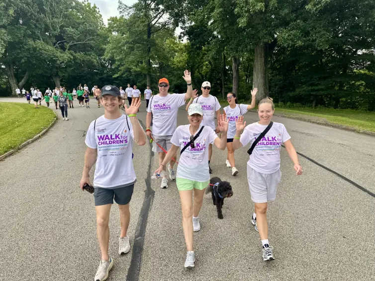 Family walking and waving. Back row (L-R) Bill Thalman, Executive VP & COO, Mark, and Bella. Front row (L-R) Alex, Diane, Heather, and Jack the family dog.